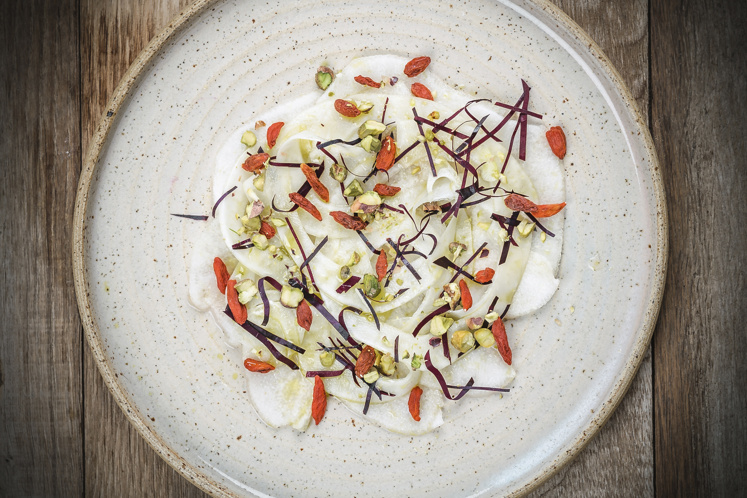 Carpaccio van rijpe peer en venkel, roze pompelmoes, pistache en gojibes