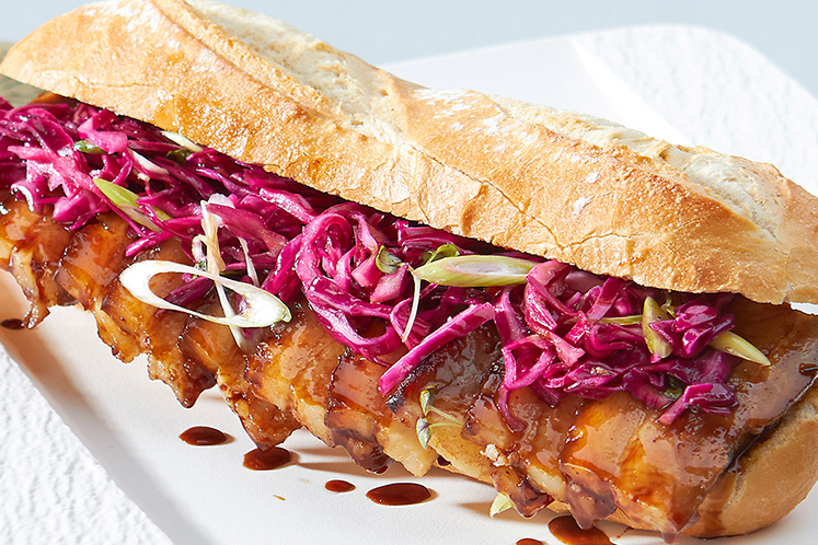 Half stokbrood met gemarineerd buikspek en kool